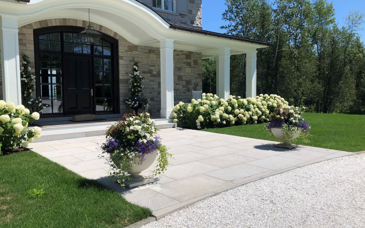 Front yard of a featured property with flower planters.